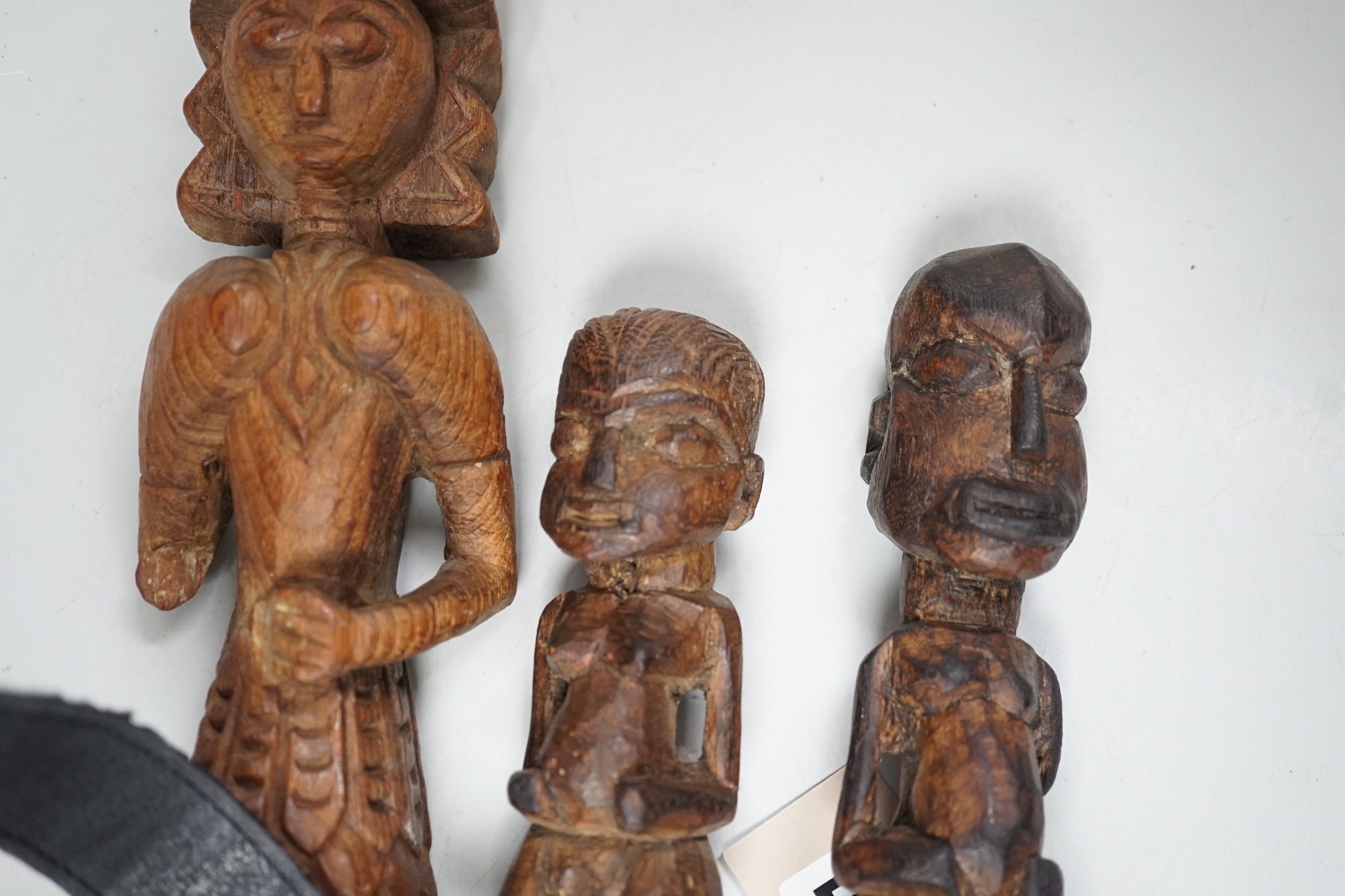 A carved teak terminal figure and two African tribal figures, largest 32cm long